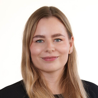 Portrait einer Frau mit langen, glatten Haaren und freundlichem Ausdruck.